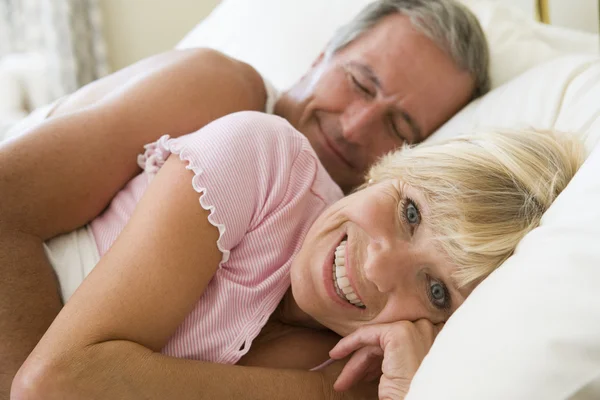 Пара лежащих вместе в постели улыбающихся — стоковое фото