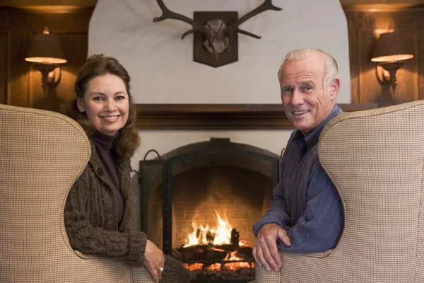 暖炉の笑顔でリビング ルームに座っているカップル — ストック写真