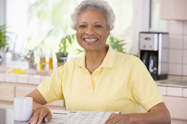 Woman Relaxing Newspaper Kitchen Smiling — Stock Photo, Image
