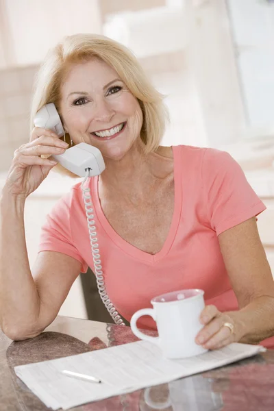 Kobieta Kuchni Przy Użyciu Telefonu Uśmiechając Się — Zdjęcie stockowe