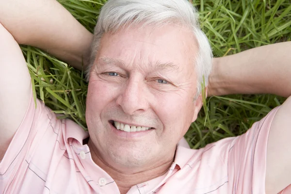 Hombre acostado en la hierba sonriendo — Foto de Stock