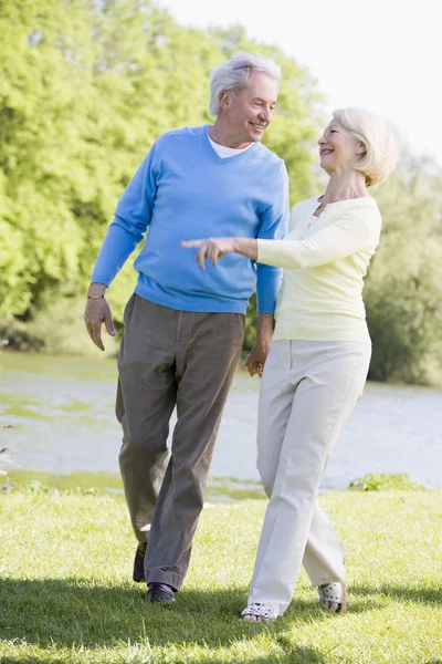 屋外公園湖笑顔で歩くカップル — ストック写真