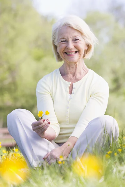 Mujer Sentada Aire Libre Sonriendo Sosteniendo Una Flor Buttercup — Foto de Stock