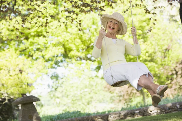 stock image Woman in a swing outdoors smiling