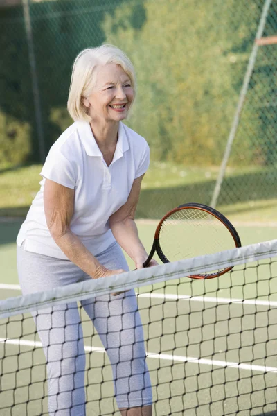 Женщина играет в теннис и улыбается — стоковое фото