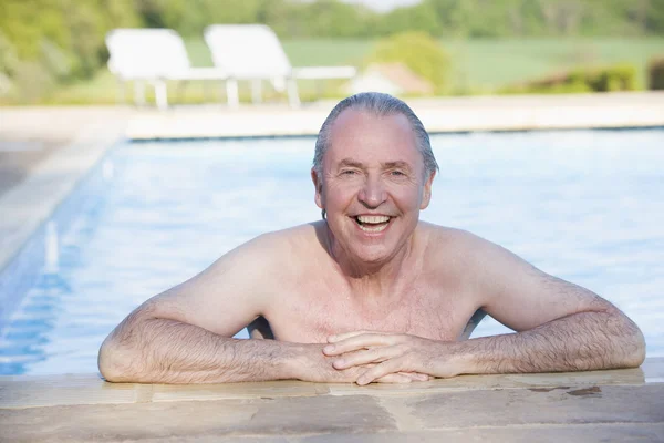 Hombre en la piscina al aire libre sonriendo — Foto de Stock