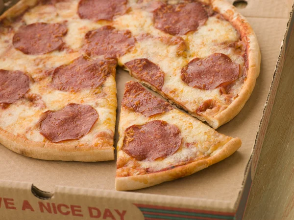 意大利辣香肠比萨饼切切片拿去盒中 — 图库照片