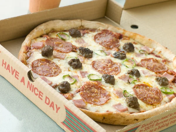 Kött fest pizza i en take away låda — Stockfoto