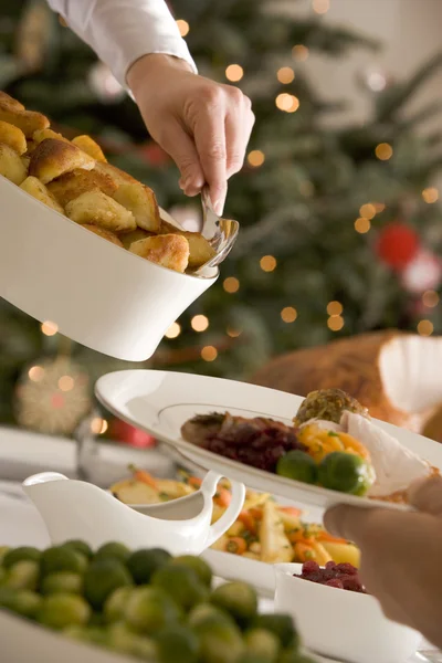 Serving Roast Potatoes at Christmas Lunch — Stock Photo, Image