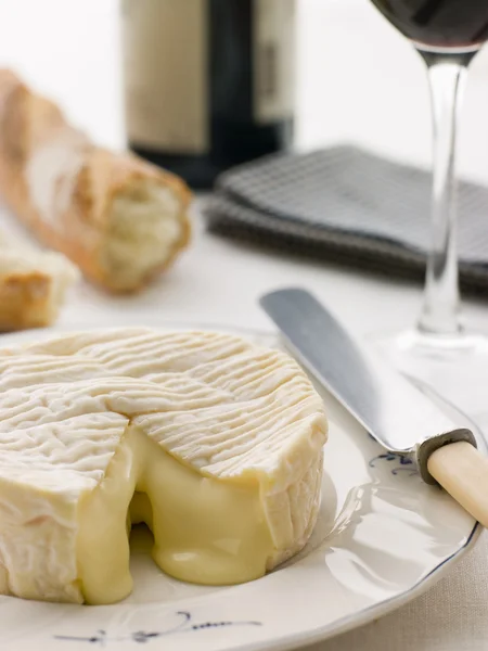 Ronda de queso camembert con palo francés y vino tinto —  Fotos de Stock
