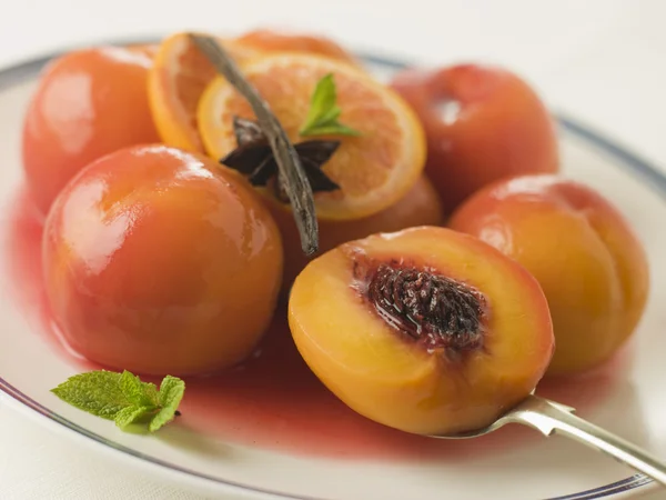 Skål med persikor pocherad i sauternes vin — Stockfoto