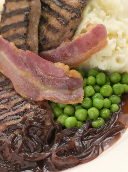 Fígado de bezerros grelhados e bacon com purê de batata e ervilhas — Fotografia de Stock
