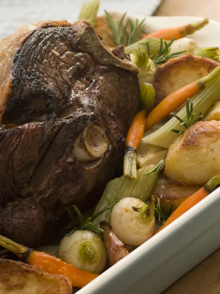 Жареная нога ягненка с жареным картофелем и овощами — стоковое фото