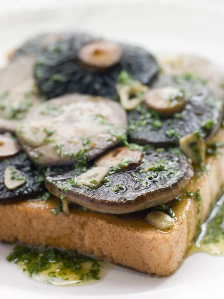 Чесночные полевые грибы на тосте с маслом петрушки — стоковое фото