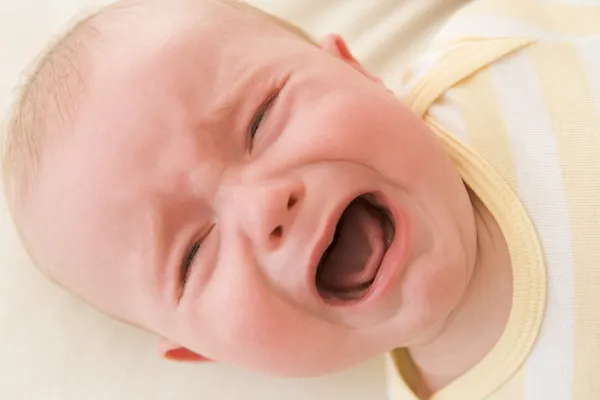 Baby lying indoors crying — Stock Photo, Image