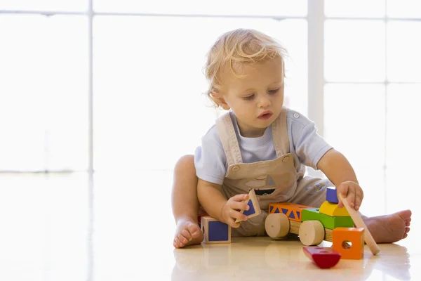 Дитина в приміщенні грає з іграшковою вантажівкою — стокове фото