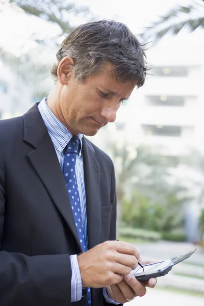 Businessman Outdoors Using Personal Digital Assistant — Stock Photo, Image