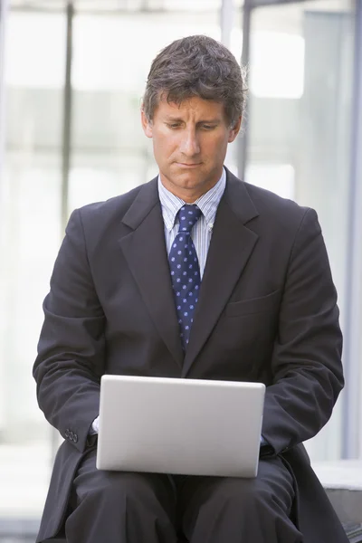 Biznesmen siedzi w holu urzędu przy użyciu laptopa — Zdjęcie stockowe