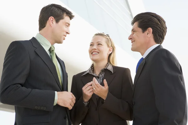 Drei Geschäftsleute, die im Freien stehen, indem sie Gespräche führen und — Stockfoto