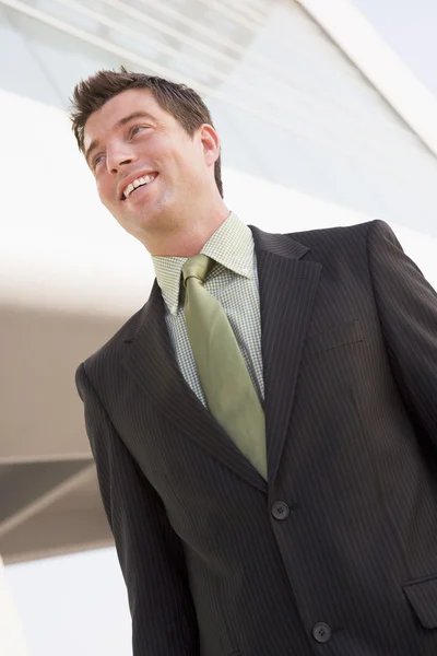 Empresário em pé ao ar livre, construindo sorrindo — Fotografia de Stock