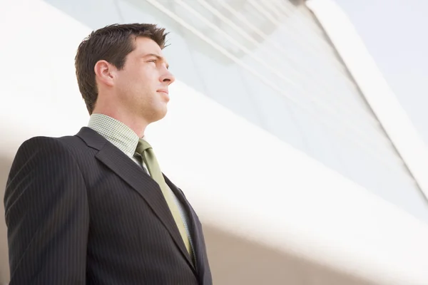 Businessman standing outdoors by building — Stock Photo, Image