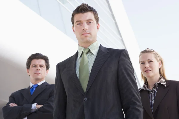Three businesspeople standing outdoors by building — Stock Photo, Image