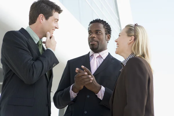 Tři podnikatelé stojící venku mluví a s — Stock fotografie