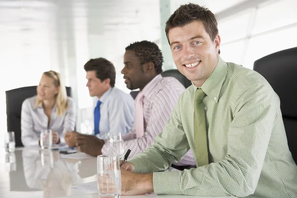Четверо бизнесменов в зале заседаний улыбаются — стоковое фото