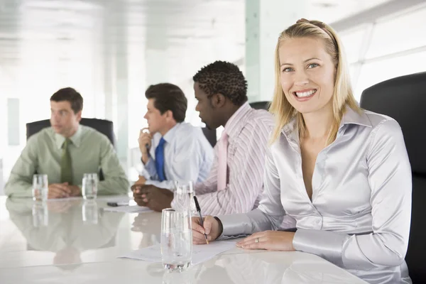 Quatro empresários em uma sala de reuniões sorrindo — Fotografia de Stock