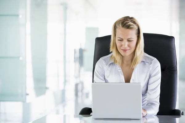 Affärskvinna i office med laptop — Stockfoto
