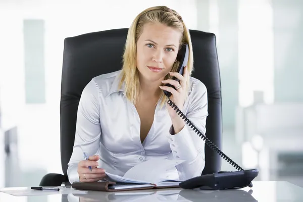 Деловая женщина в офисе с личным органайзером, открытым по телефону — стоковое фото