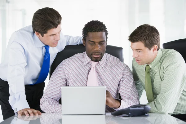 Drie ondernemers in een directiekamer kijken naar laptop — Stockfoto