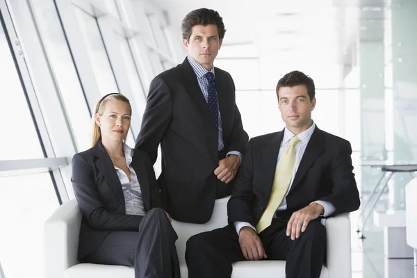 オフィスのロビーに座っている 3 つのビジネスマン — ストック写真