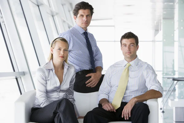 Tres empresarios sentados en el vestíbulo de oficinas — Foto de Stock