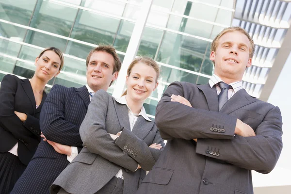 Vier Geschäftsleute, die im Freien stehen und lächeln — Stockfoto