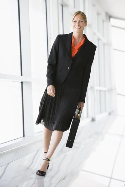 Businesswoman walking in corridor smiling — Stock Photo, Image