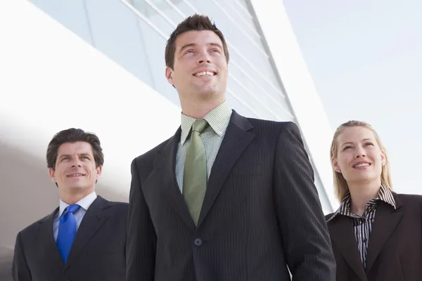 Drei Geschäftsleute, die im Freien stehen und lächeln — Stockfoto