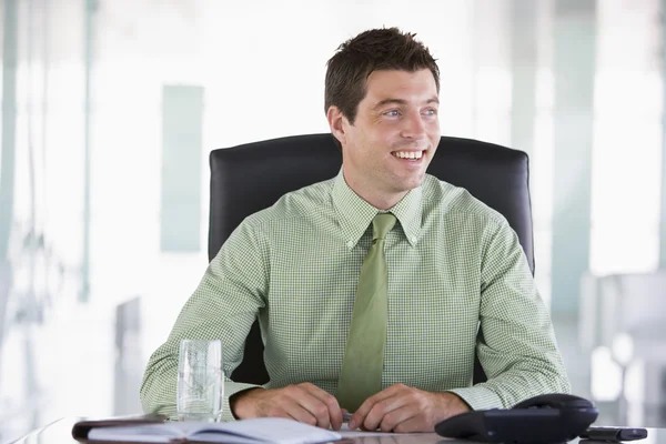 個人的なオルガナイザーを笑顔でオフィスに座っている実業家 — ストック写真