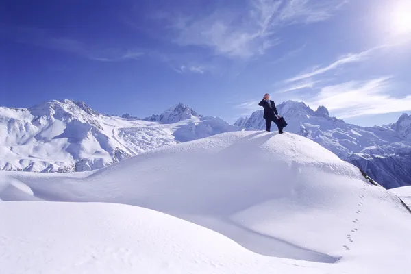 Podnikatel venku na zasněžené hory, pomocí mobilního telefonu — Stock fotografie