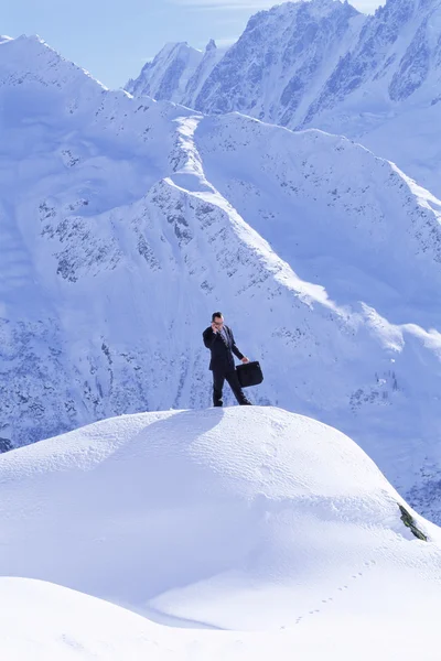 Affärsman utomhus på snöiga berg med mobiltelefon — Stockfoto