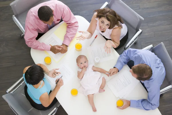 Vier Ondernemers Directiekamer Met Een Baby Liggend Tafel — Stockfoto