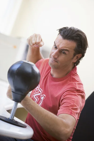 Empresario en la oficina usando un pequeño saco de boxeo para aliviar el estrés — Foto de Stock
