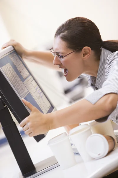 Mujer en la sala de computadoras agarrando su monitor y gritando —  Fotos de Stock