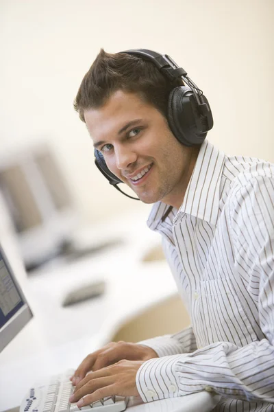 Homem Usando Fones Ouvido Sala Informática Digitando Sorrindo — Fotografia de Stock