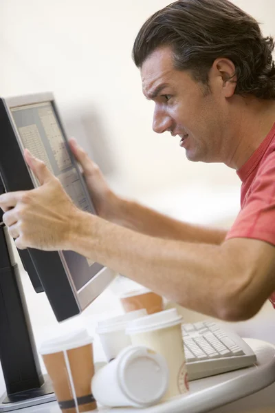 Hombre en la sala de computadoras con muchas tazas vacías de café agarrando su —  Fotos de Stock