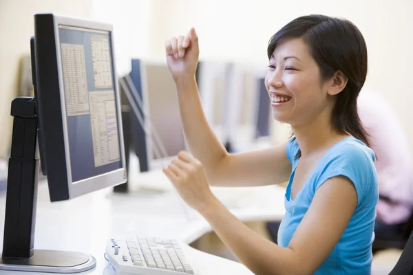 Женщина в компьютерной комнате аплодирует и улыбается — стоковое фото