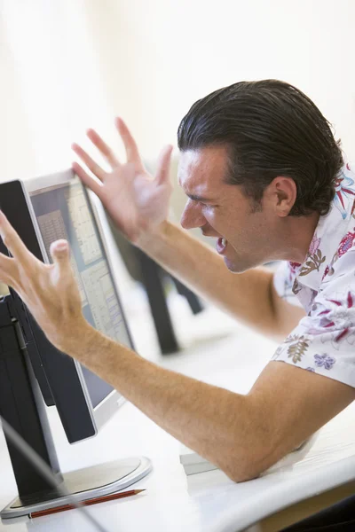 Man in computer room frustrated at monitor — Stock Photo, Image