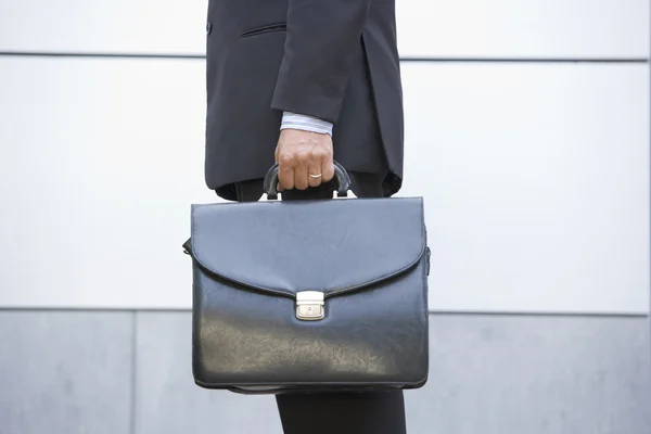 Бізнесмен тримає портфель на відкритому повітрі — стокове фото