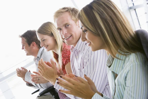 Vier Geschäftsleute applaudieren lächelnd drinnen — Stockfoto