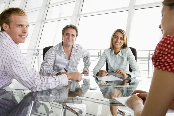 Quatro Empresários Uma Sala Reuniões Com Papelada Sorrindo — Fotografia de Stock